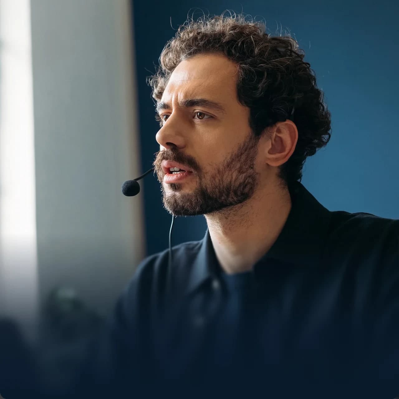 A support agent wearing a headset, speaking